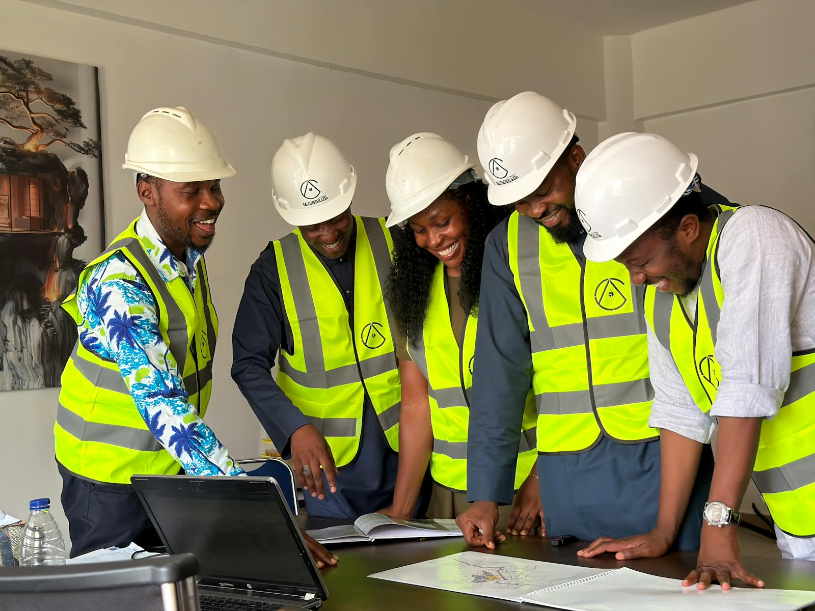 Equipe d'ingenieurs noirs en casques revisant des plans techniques