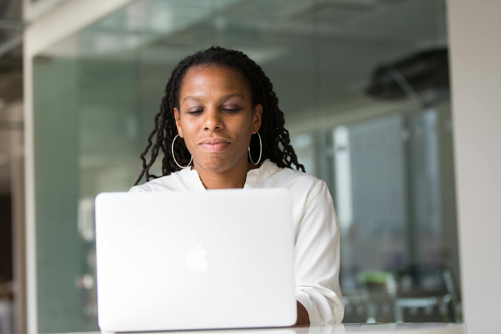 Professionnelle noire travaillant sur un ordinateur portable dans un bureau moderne